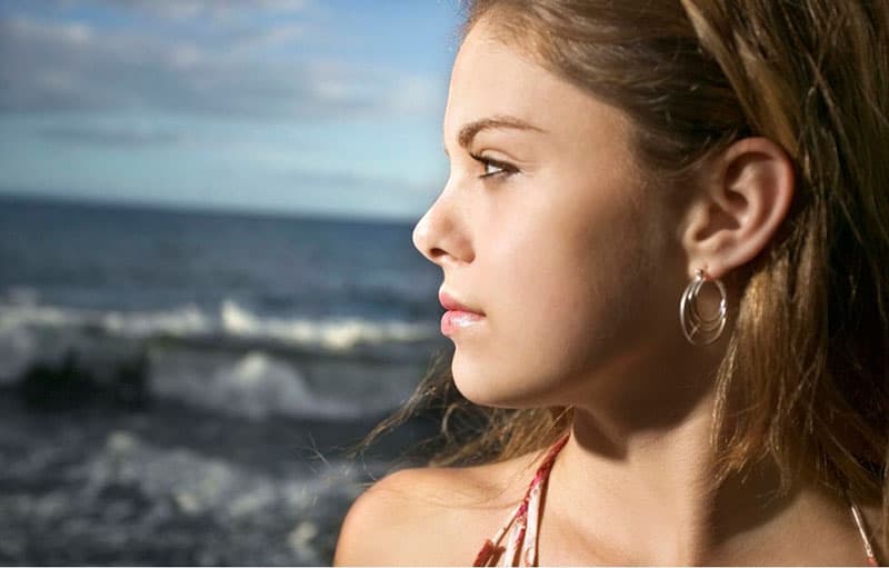 sideview of a pensive woman staring far near the sea