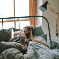 um homem e uma mulher abraçados na cama