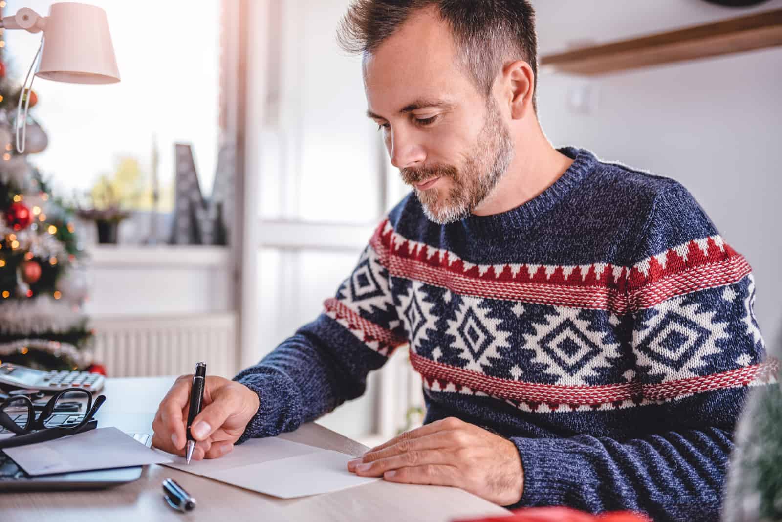 um homem senta-se à mesa e escreve