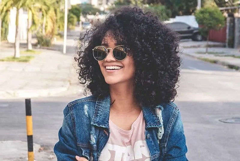 a portrait of a smiling black woman with sunglasses