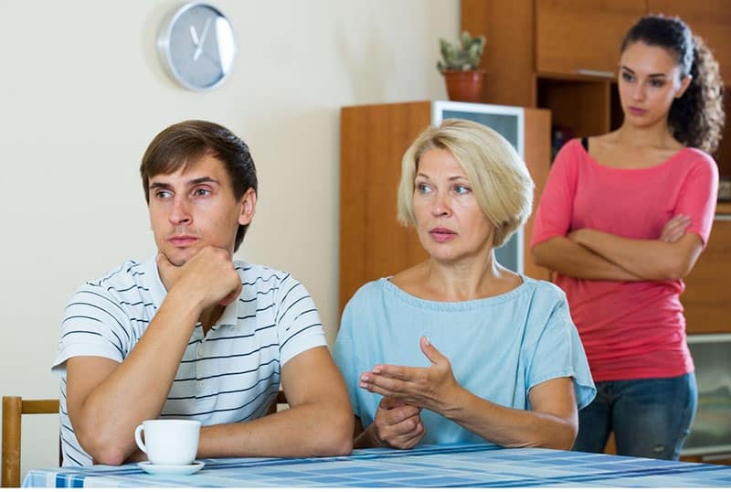 angry mother in law beside her son with wife standing at the back