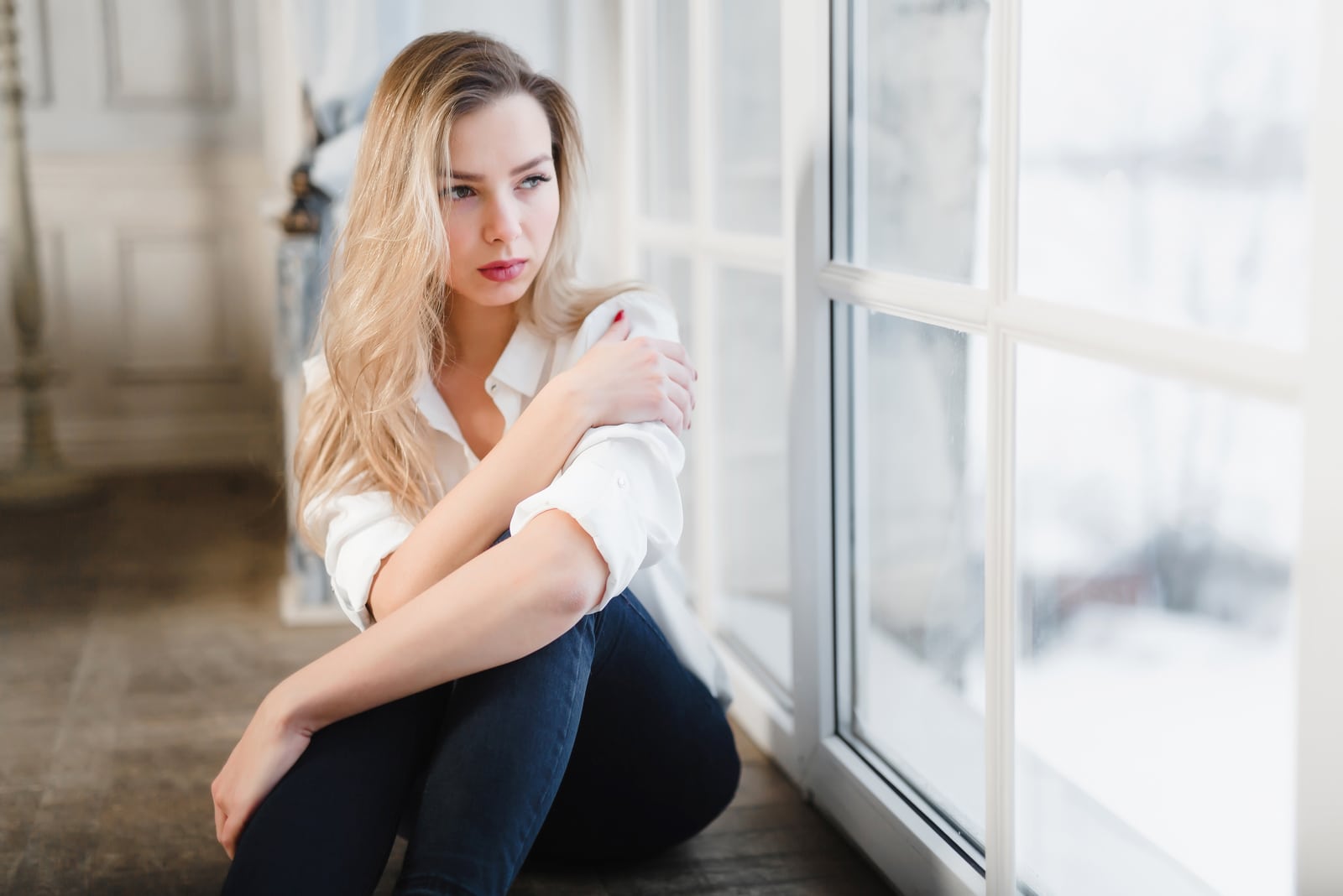 confident beautiful blond woman sitting by the window