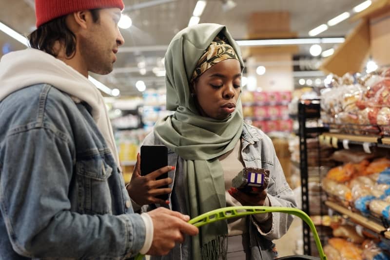 uomo e donna che acquistano generi alimentari al mercato