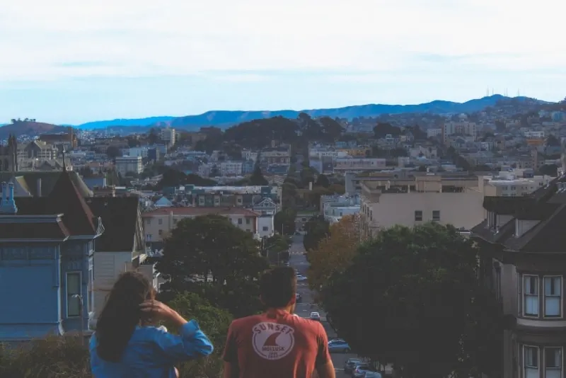 woman in denim jacket and man looking at houses