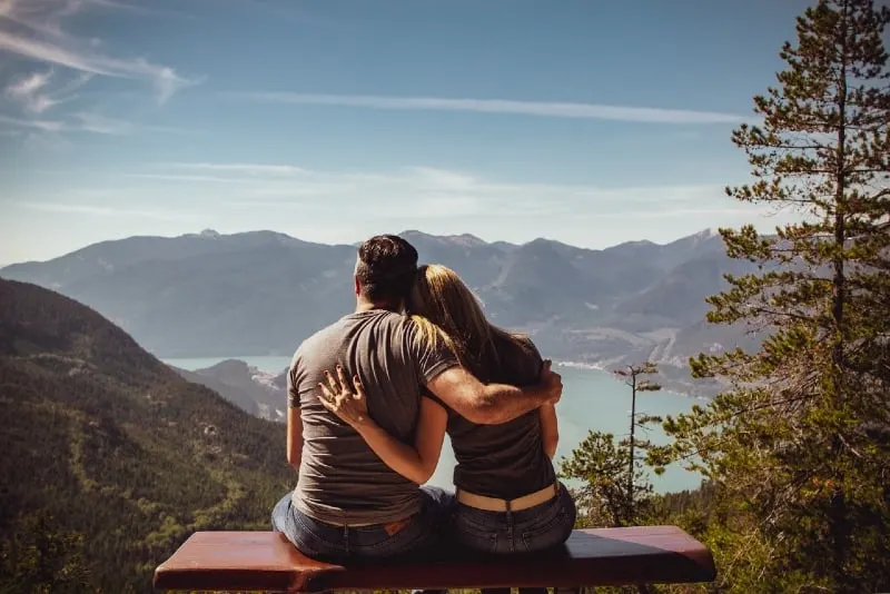 man and woman sitting on bench and hugging