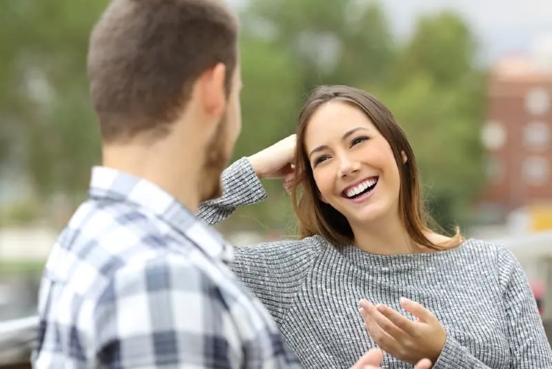 smiling woman and man sitting outdoor and talking