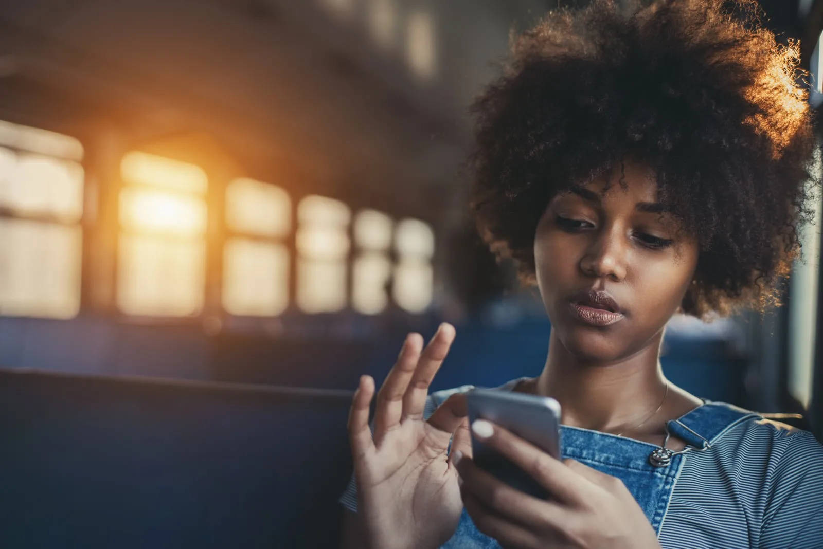  girl using smart phone while sitting alone in suburban train