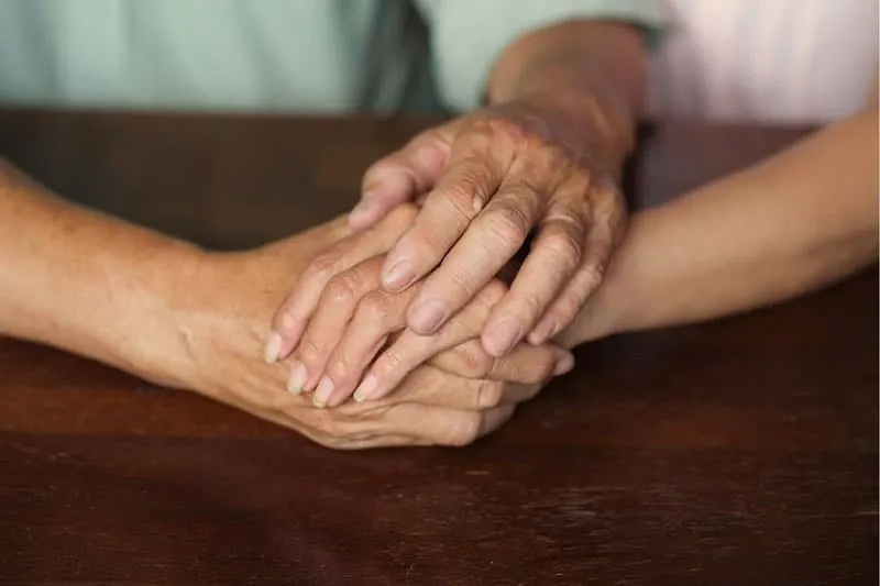 hand placed on top of the other hand placed in the table