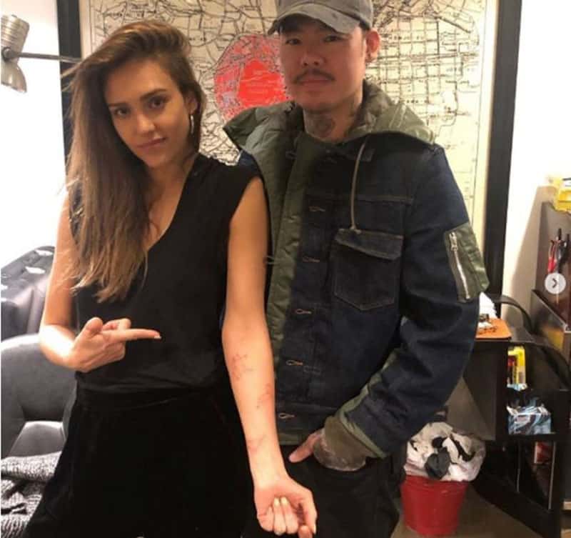 kids zodiac constellation tattooed on a womans arm standing beside a man