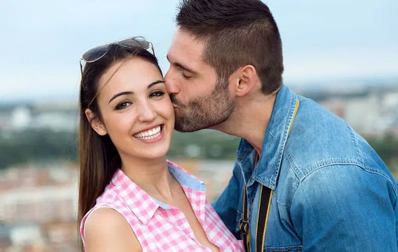 lovely couple where the man kissing the cheeks of the woman