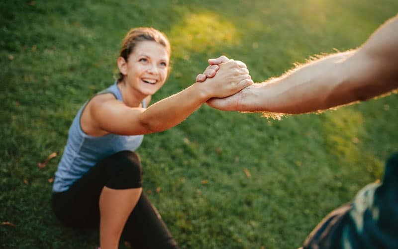 man helping his girlfriend standing up wearing athletic wear