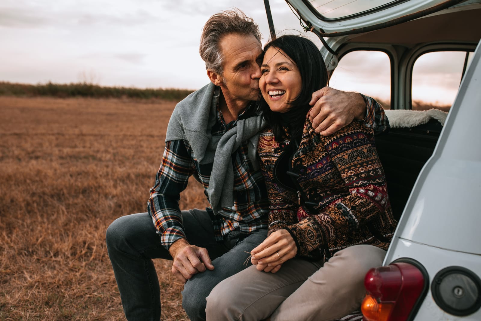 man hugging and kissing woman