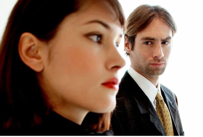 man staring at a woman at a distance wearing office suit