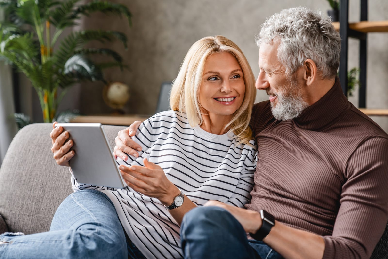 middle aged couple sitting on sofa