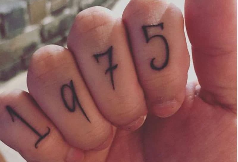 tatuaggio dell'anno di nascita della mamma 1975 inciso sulle dita