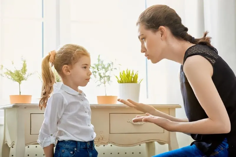 mother in black top scolding child