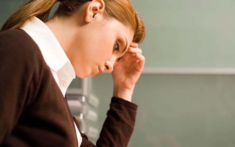 pensive young lady wearing office outfit with hand on her head