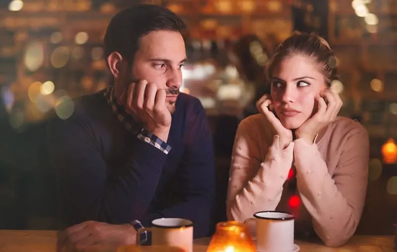 sad couple dating in a cafe looking at each other