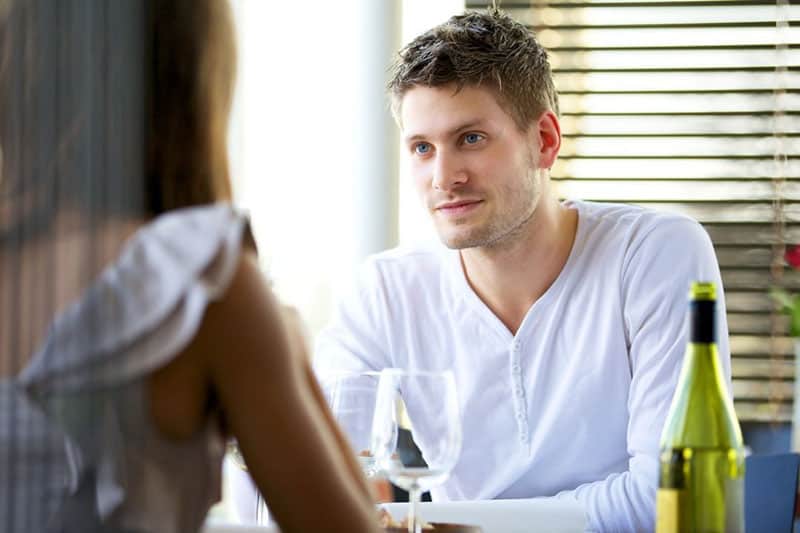 serious couple converse in the table with wine 