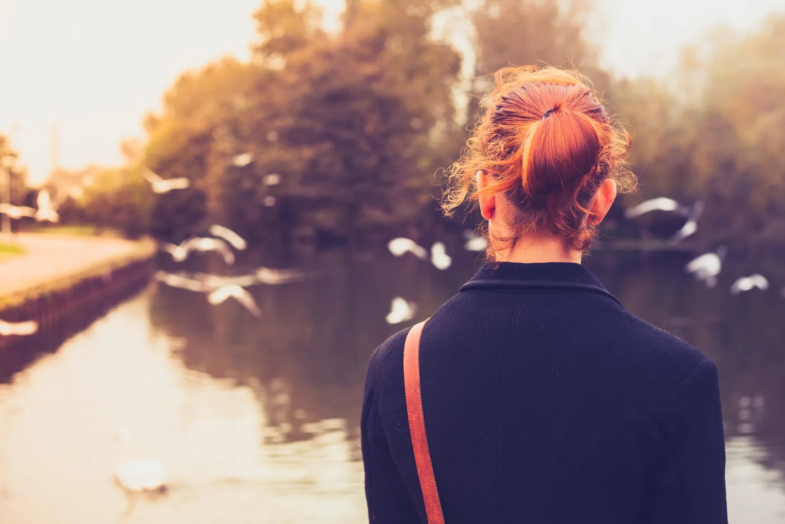 the woman stands alone by the river
