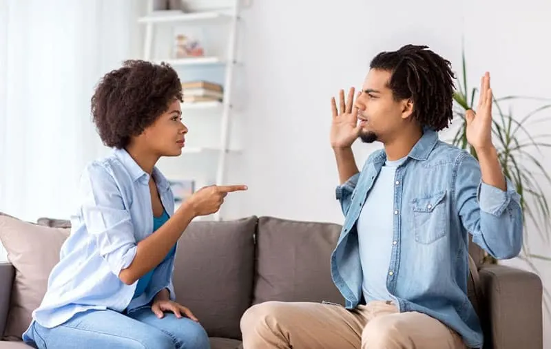 unhappy couple arguing in the sofa inside the living room