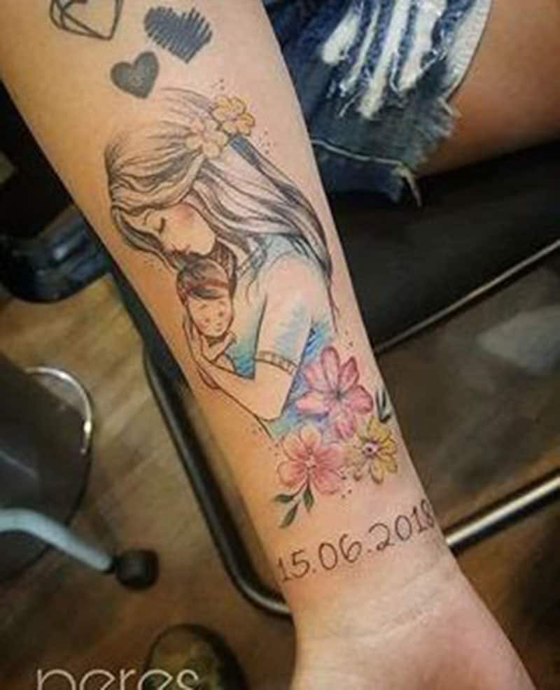 donna teneva il bambino in braccio tatuaggio inchiostrato sulle braccia