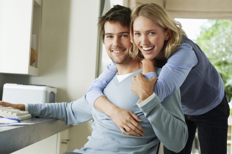 woman hugging man from behind at home