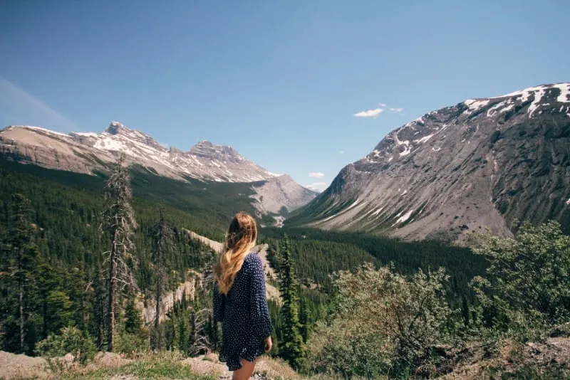 blonde woman in polka dot dress looking at mountains
