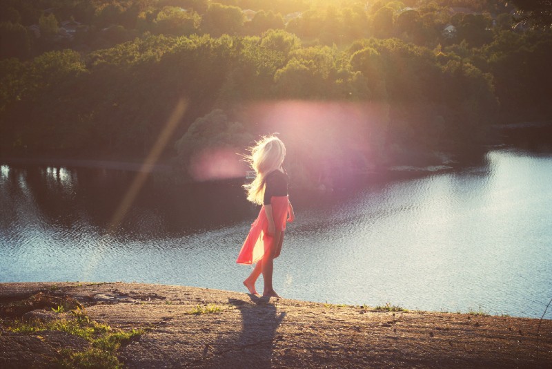 blond woman in black top looking at water