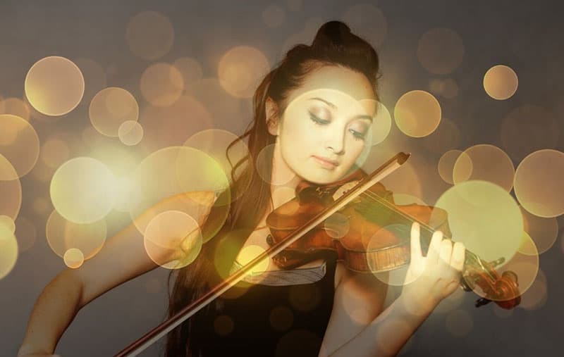 woman playing violin with lights surrounding