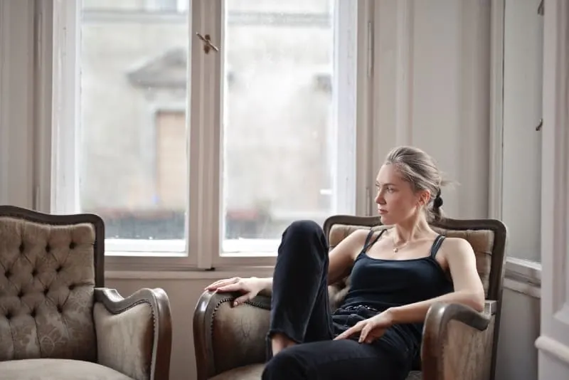 woman in black top sitting on chair