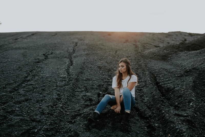 woman in white t-shirt sitting on ground