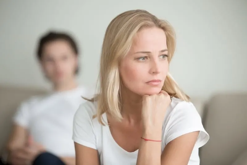 woman in white t-shirt sitting on sofa near man