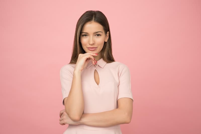 woman in pink top standing near pink wall
