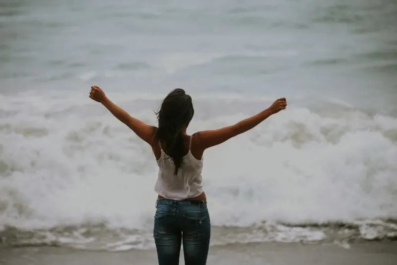 woman in white top standing on the shore