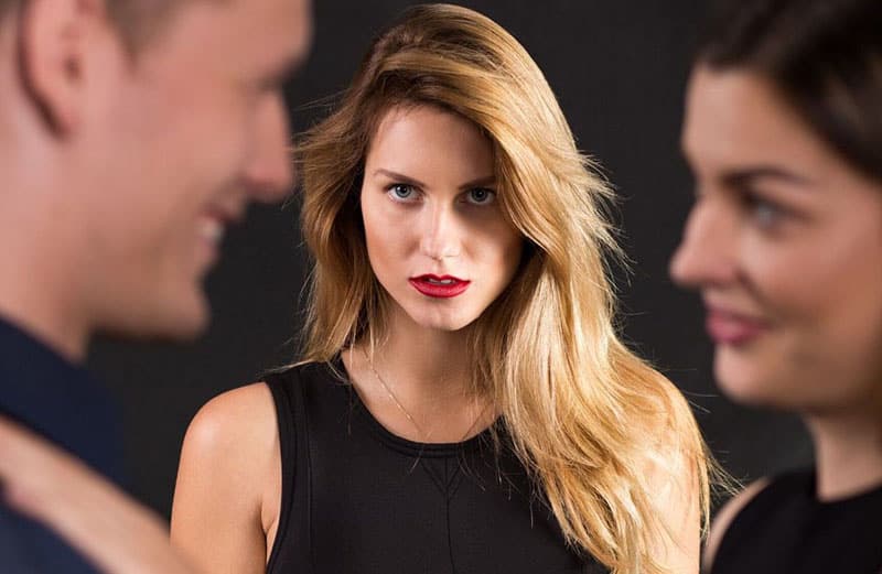 woman staring at two couple looking jealous wearing black dress