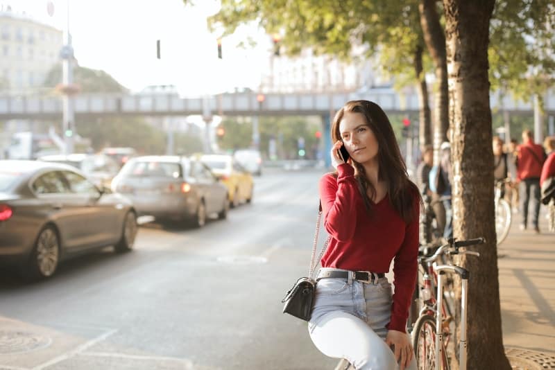 woman in red sweater talking on the phone outdoor