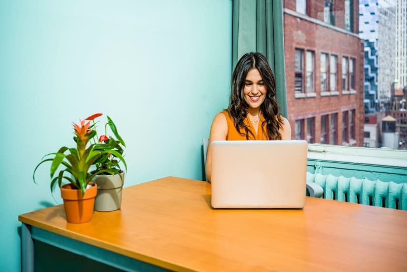 woman in yellow top using laptop