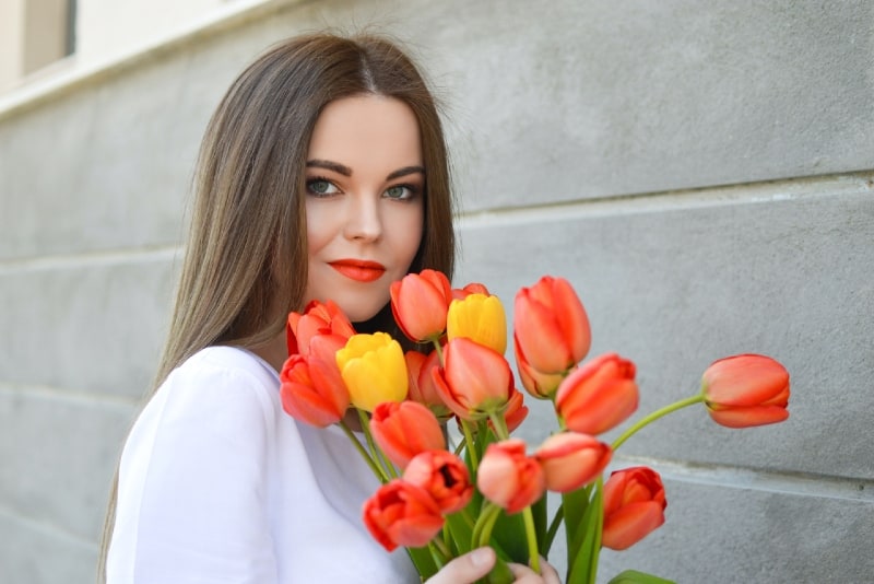 donna con bouquet di tulipani arancioni e gialli