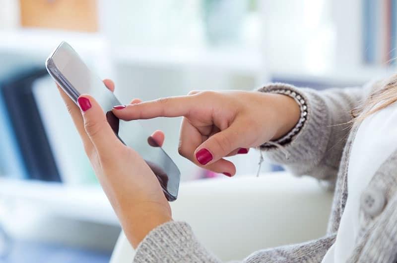 mano de mujer golpeando el smartphone