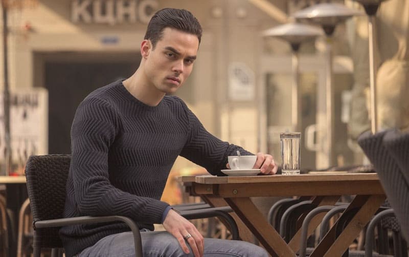 young angry man having coffee in a cafe outdoors