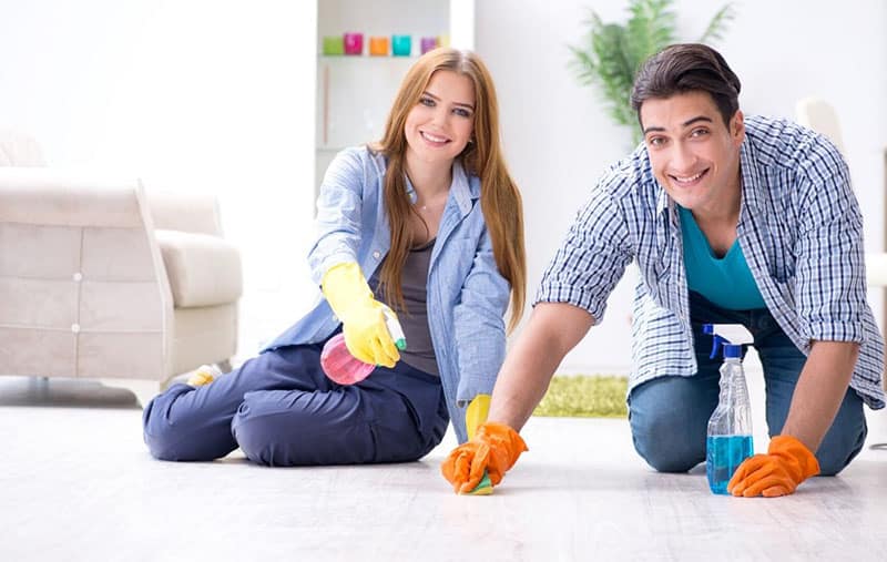 young family cleaning the floor of their house