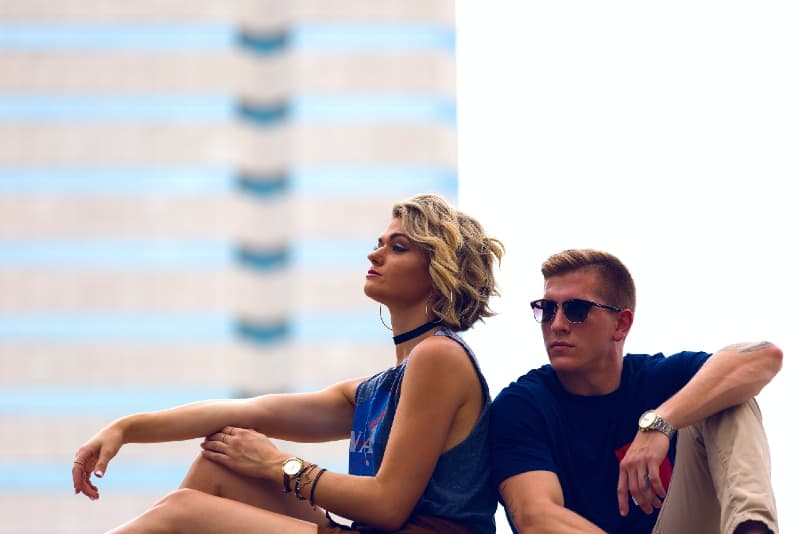 man and woman sitting on rooftop during daytime