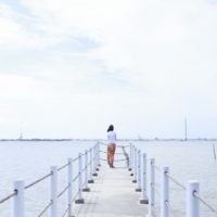 mujer con camiseta blanca de pie en el muelle