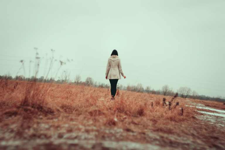 Chica joven caminando por un campo de hierba