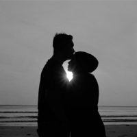 silhouette of a man and woman standing on the beach