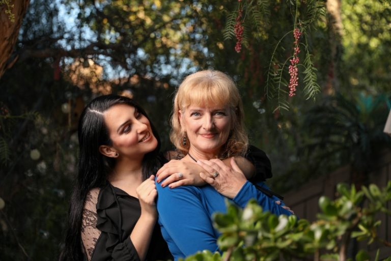 woman in black top hugging woman in blue shirt