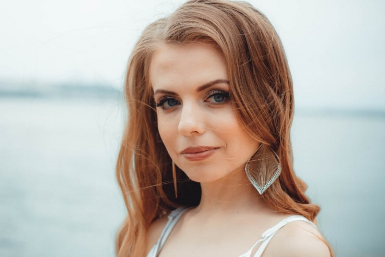 woman with earrings standing near water