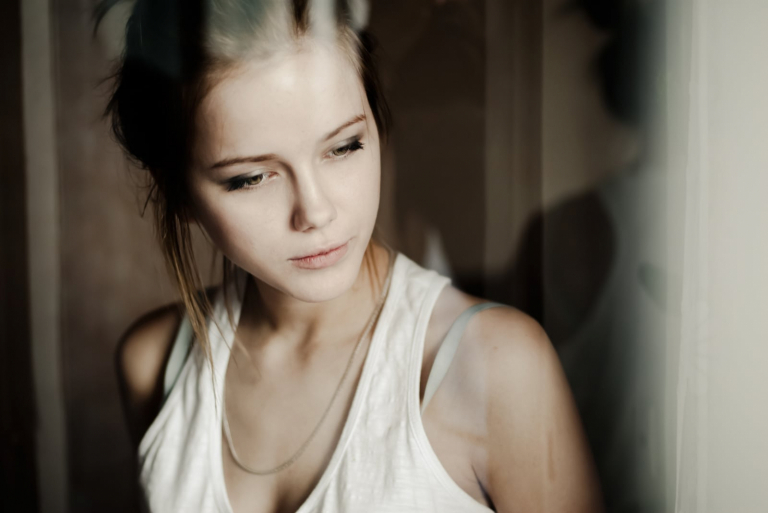 a beautiful sad girl looking out the window