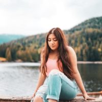 woman in blue denim jeans sitting on wooden dock